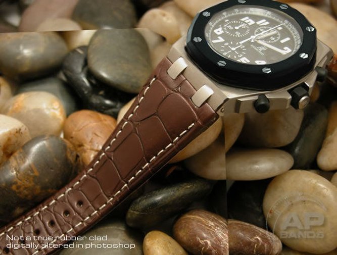 Brown leather watch strap with white stitching, showcasing its texture against a bed of smooth stones.